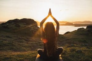 Young woman practicing yoga outdoors. Spiritual harmony, introspection and wellbeing concept